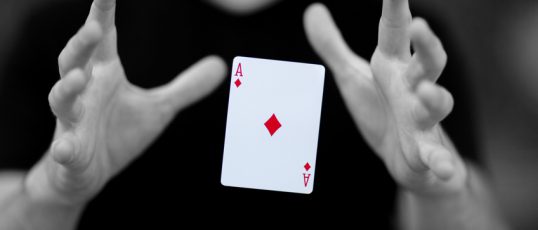 Magician levitating a card magically though mid-air